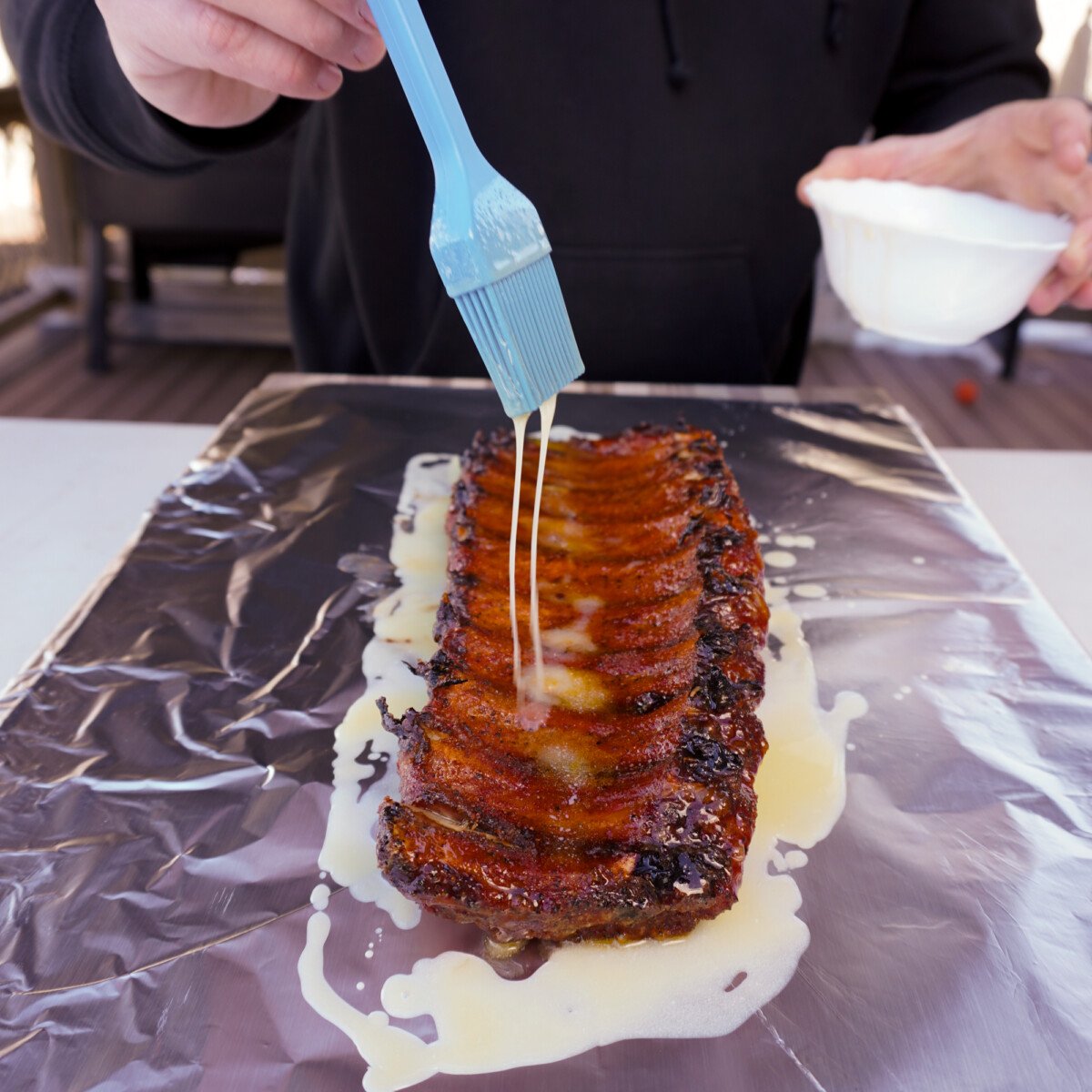 drizzling butter on smoked ribs.
