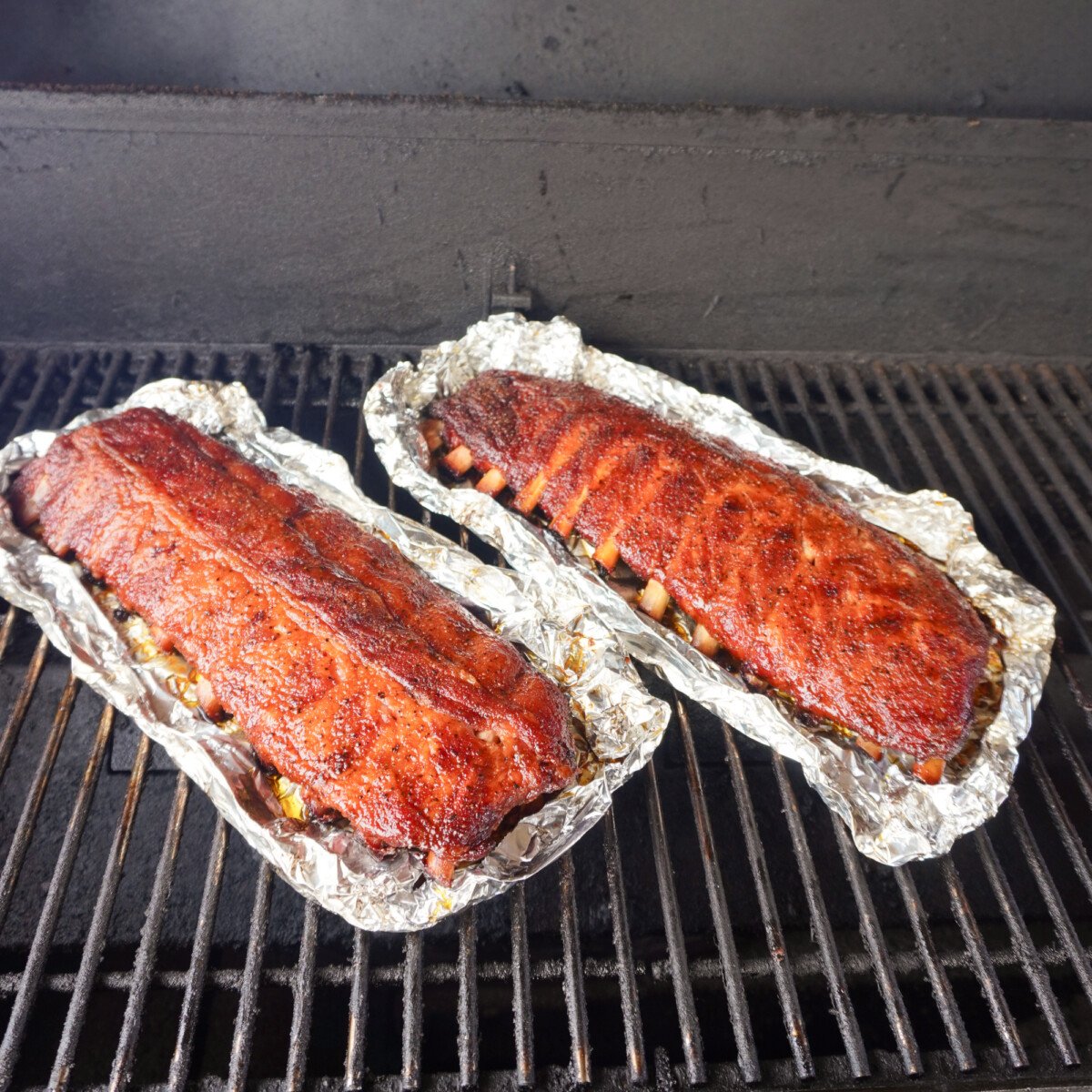 Unwrapped classic bbq baby back ribs on the smoker.