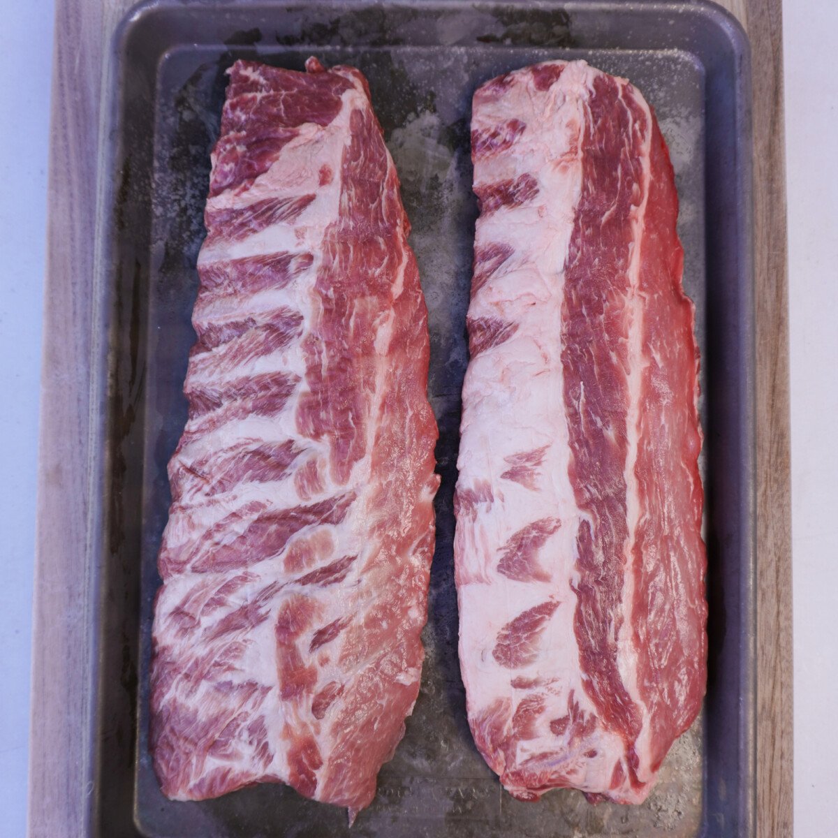raw ribs on a sheet pan.