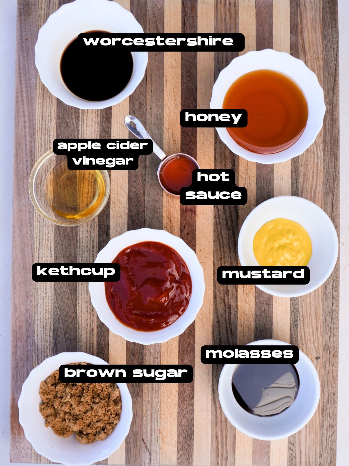 bowls on a cutting board with all the ingredients for a sweet and tangy bbq sauce.