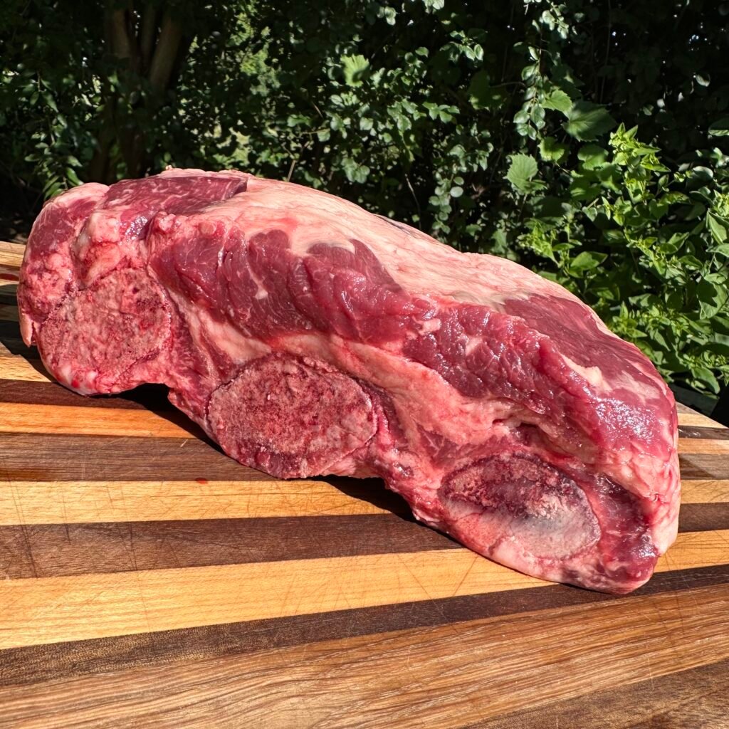 raw rack of beef ribs on a cutting board. 