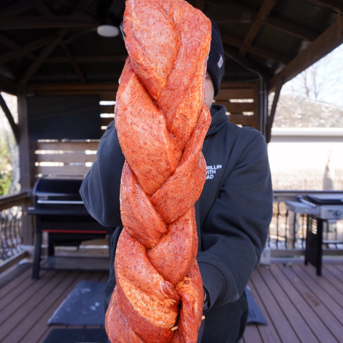 seasoned and braided pork loin presented vertically.