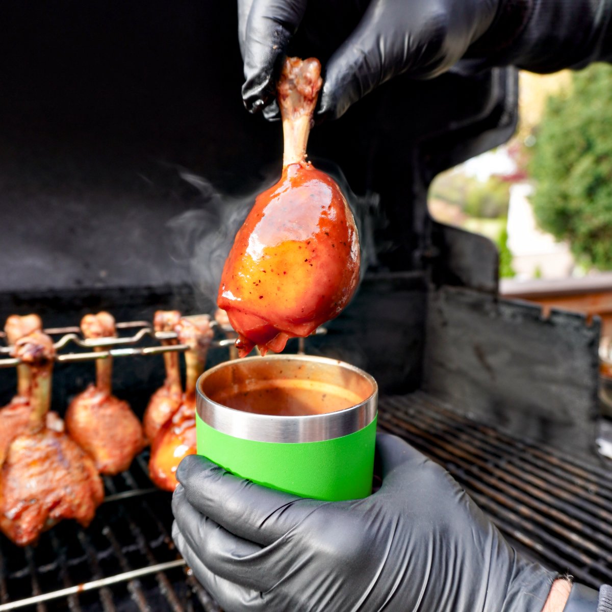 chicken lollipops being dunked in bbq sauce. 