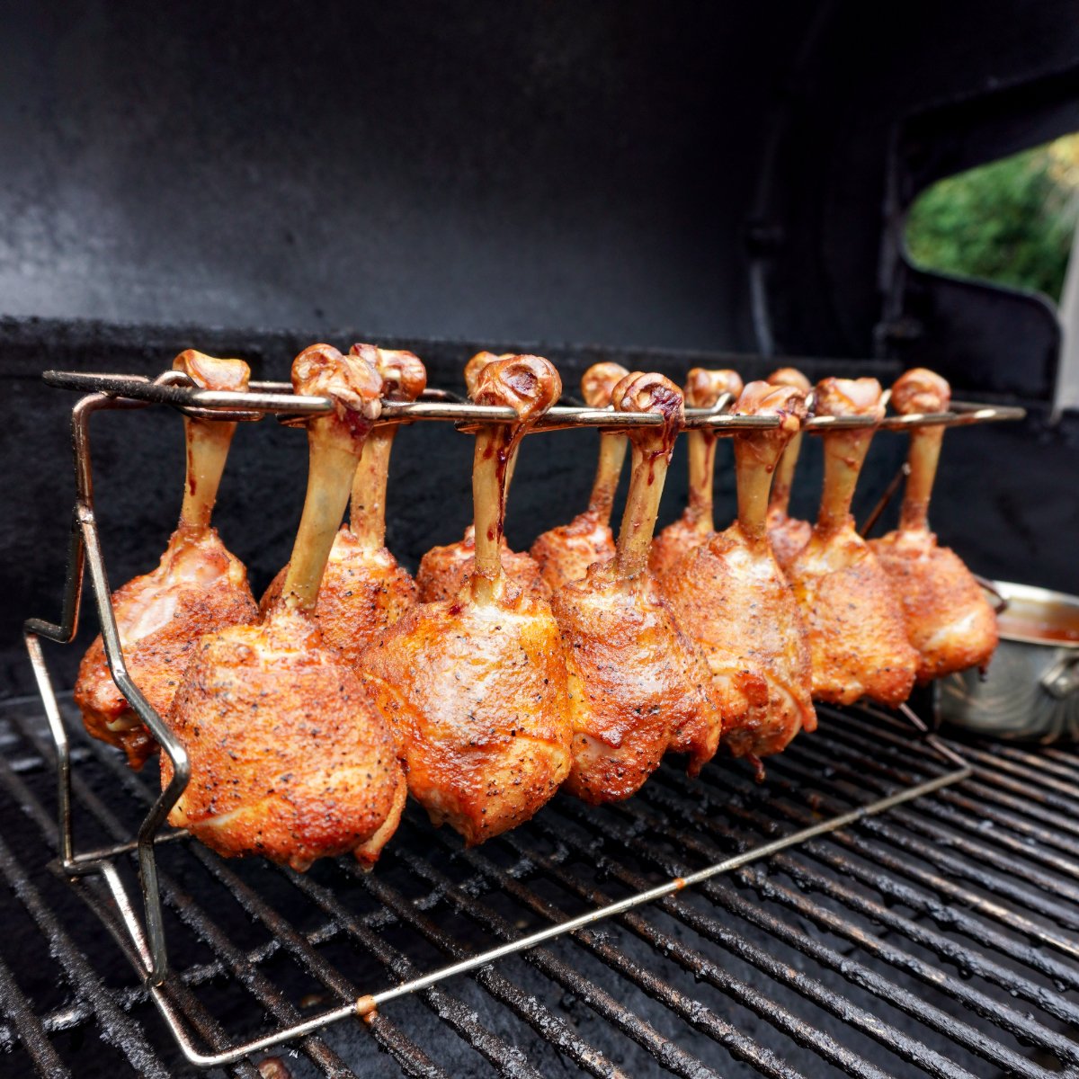 chicken lollipops on the chicken rack on the grill. 