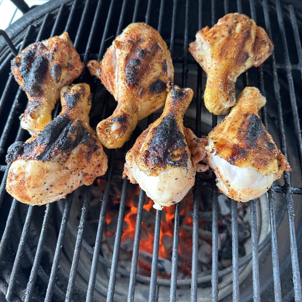 Grilled chicken drumsticks  in dr pepper bbq sauce on a hot grill.