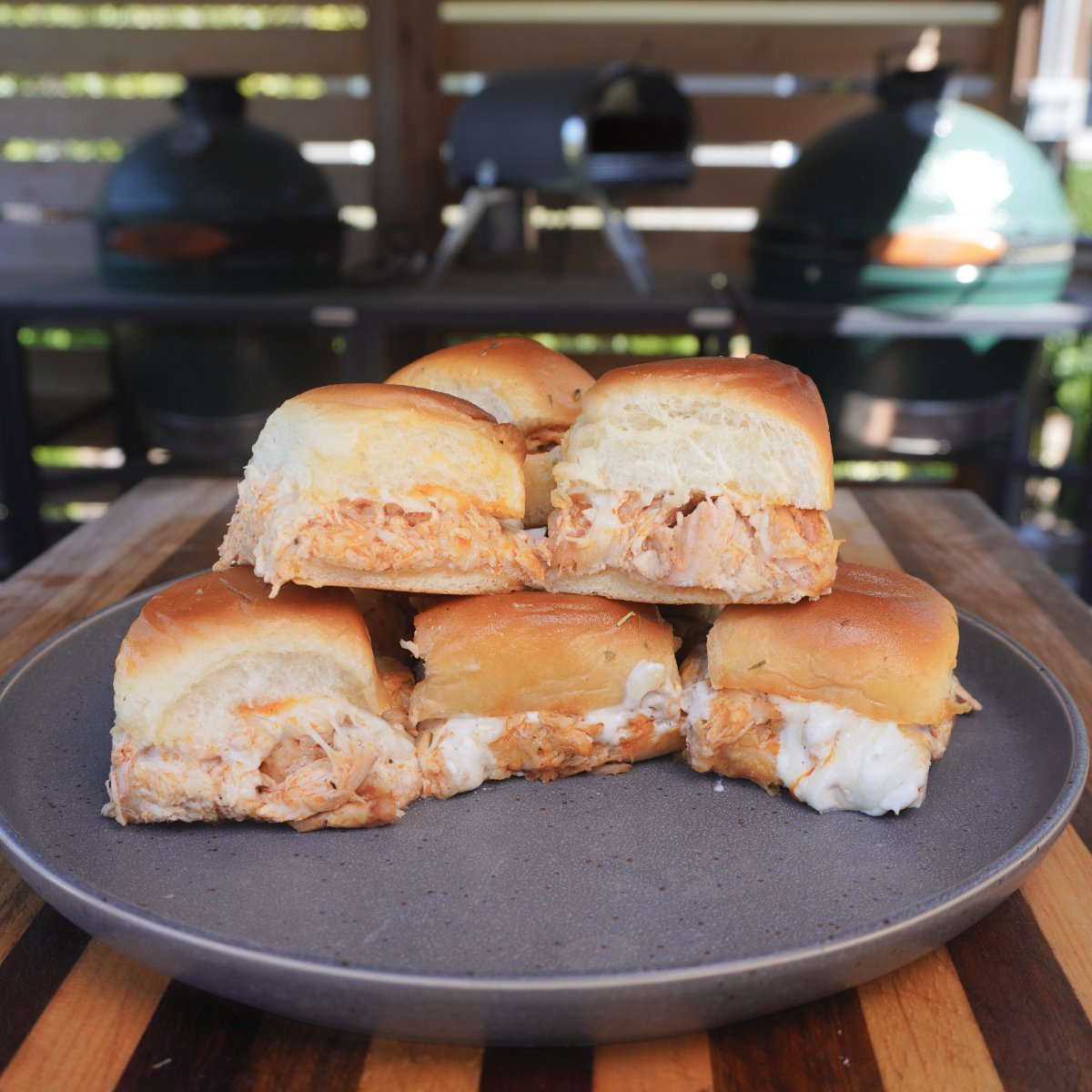 stack of buffalo chicken sliders on a round grey plate.