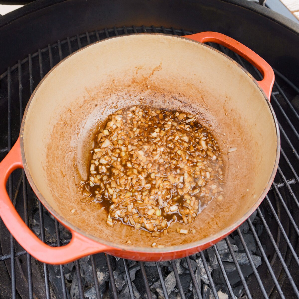 sauteed onions in a dutch oven over a grill.