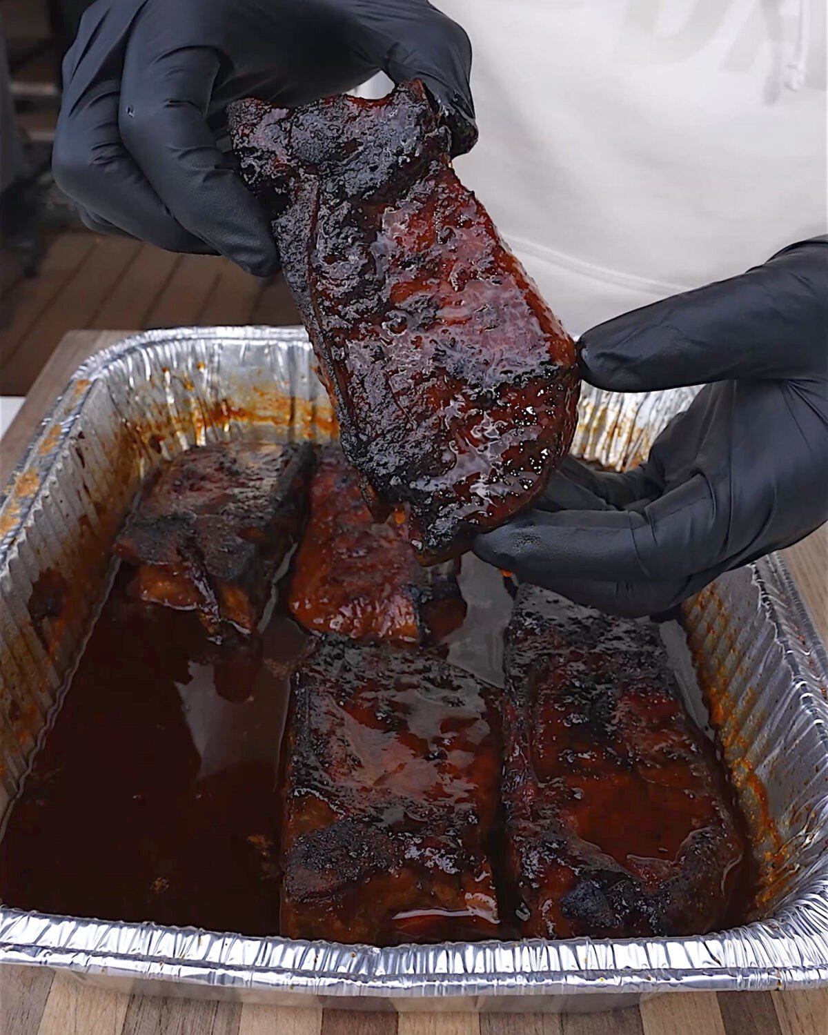 grilled country style ribs in sauce in a foil pan. 