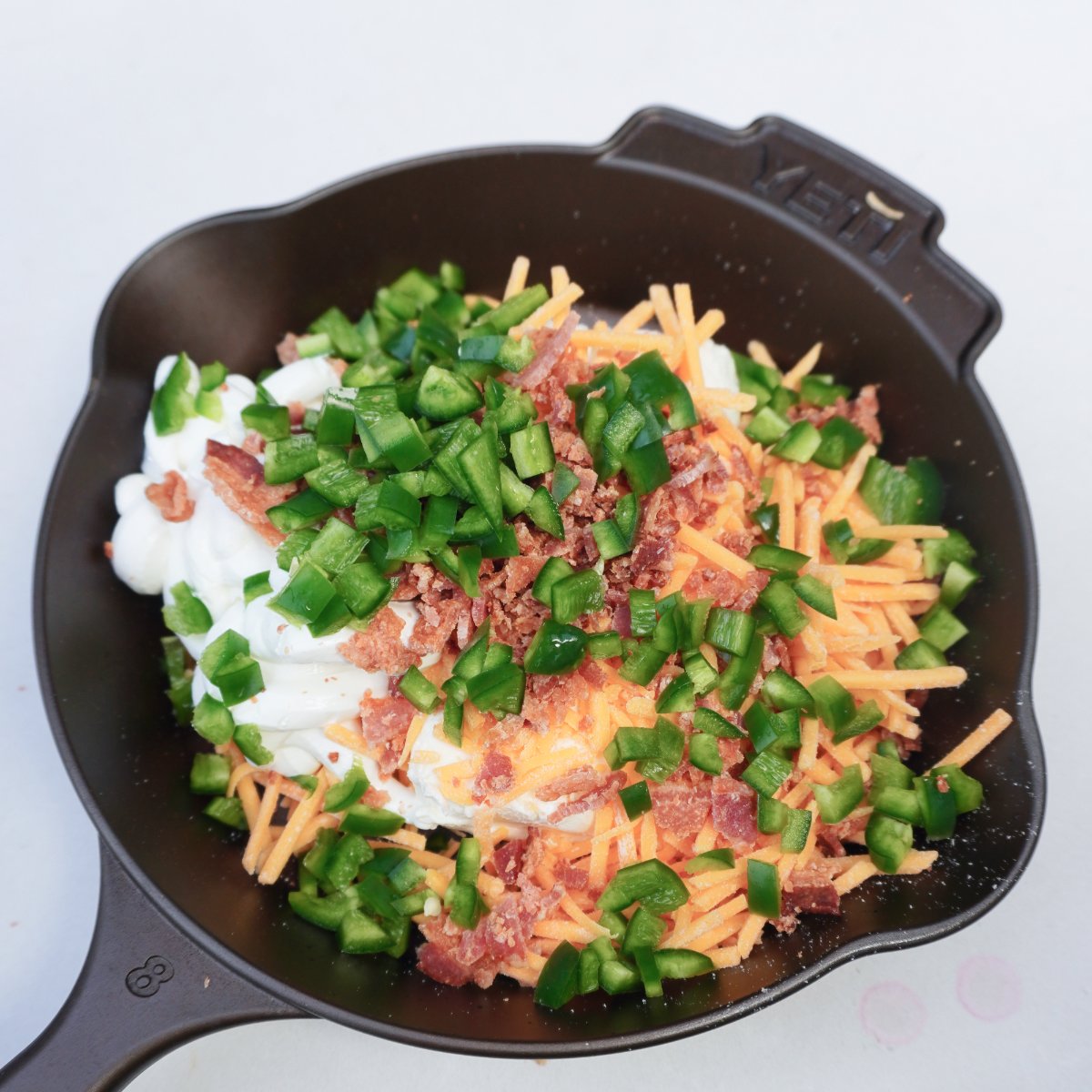 Cast iron skillet filled with all the raw ingredients for a dip.
