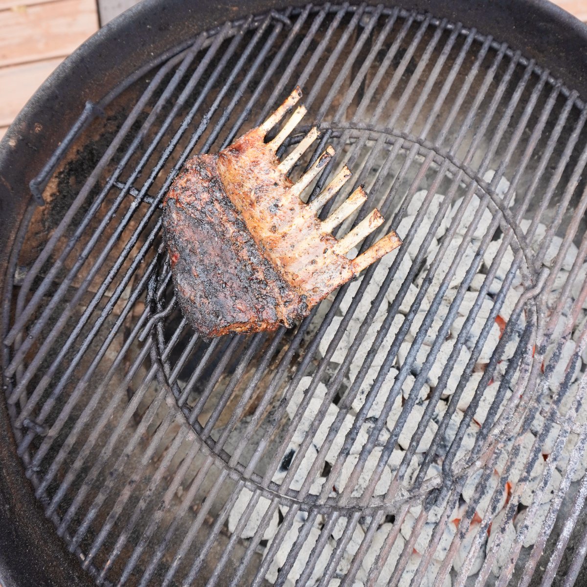 smoking the grilled rack of lamb over indirect heat on a charcoal grill.