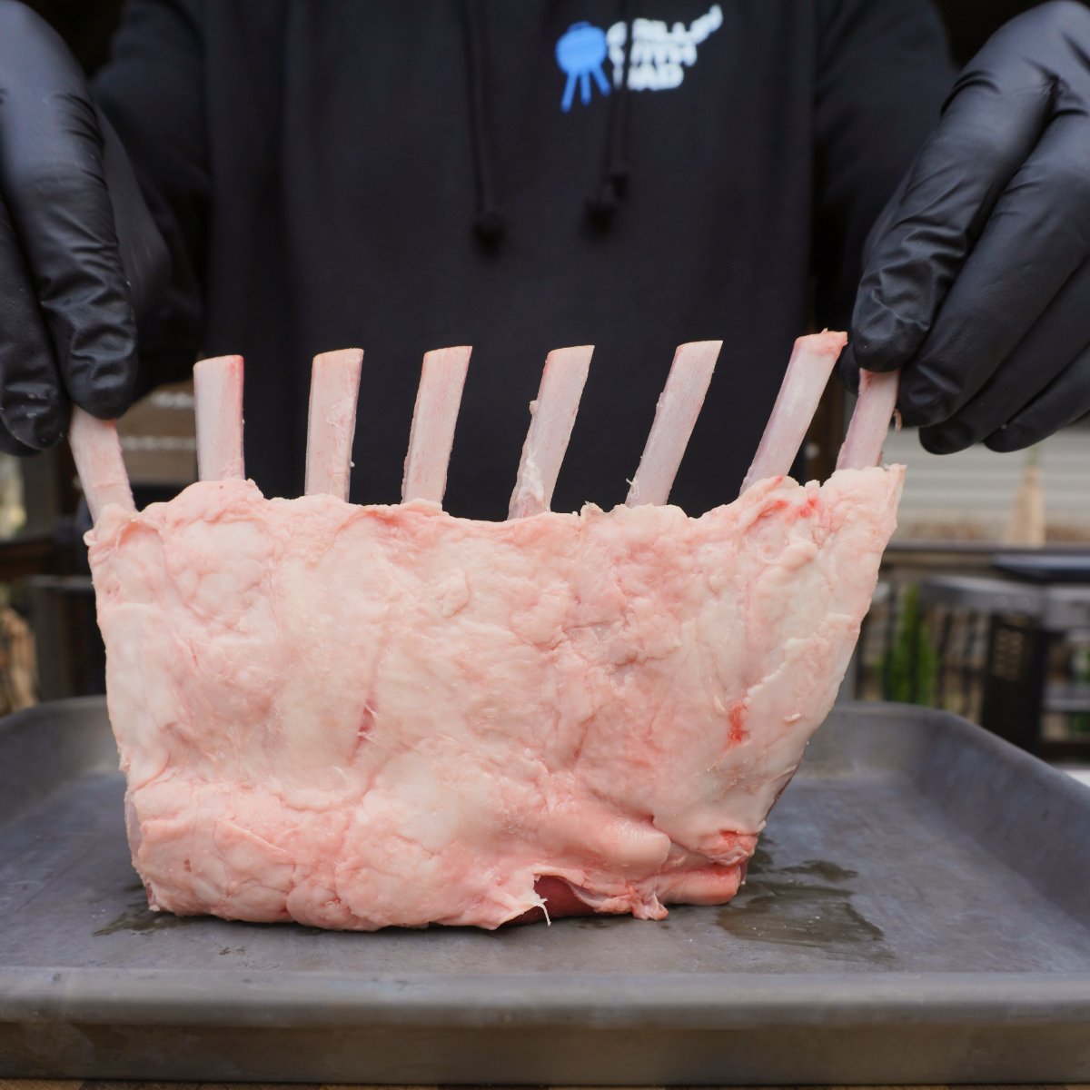 trimmed raw rack of lamb on a metal tray