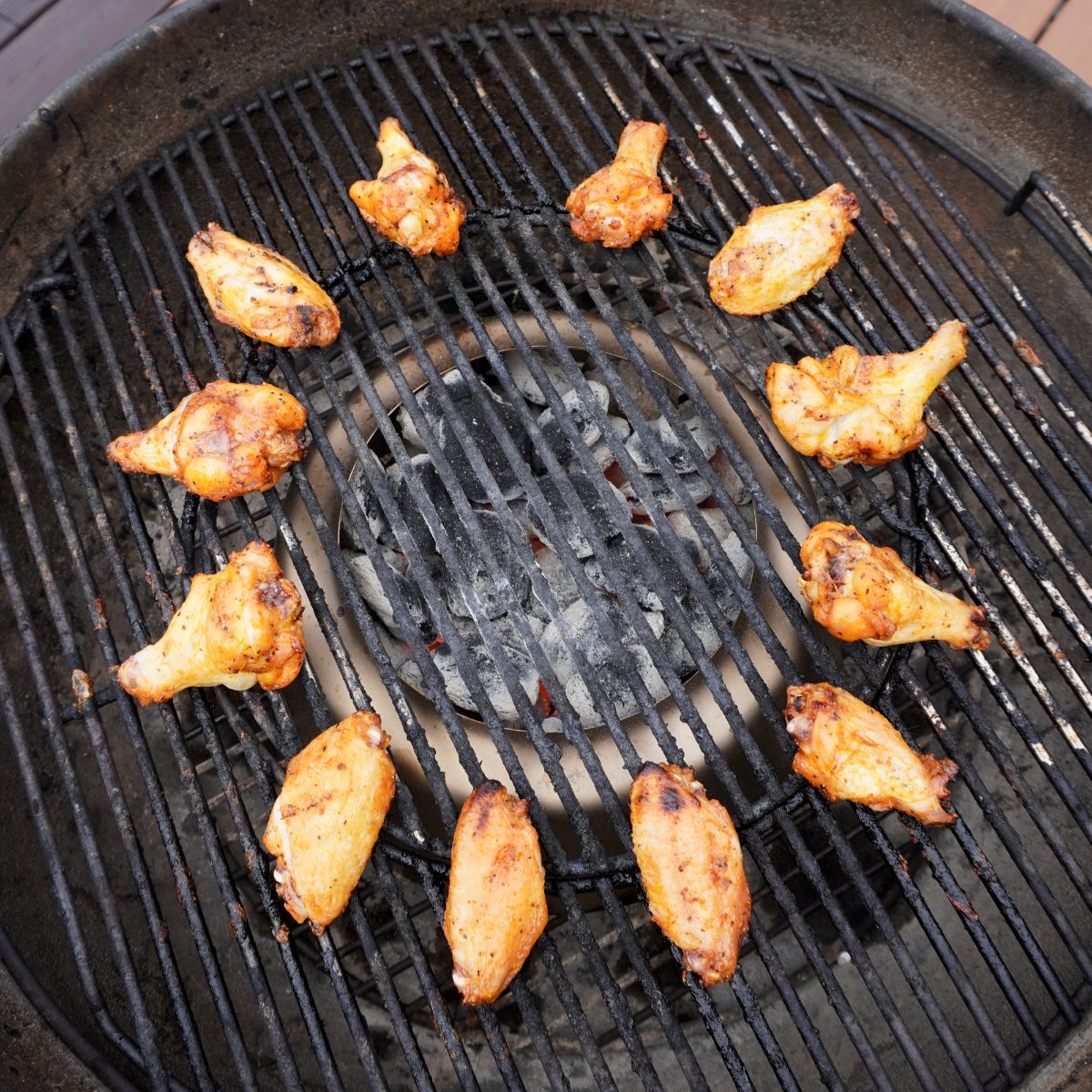 Grilled honey lime chicken wings placed in a circle directly on the grill grates.