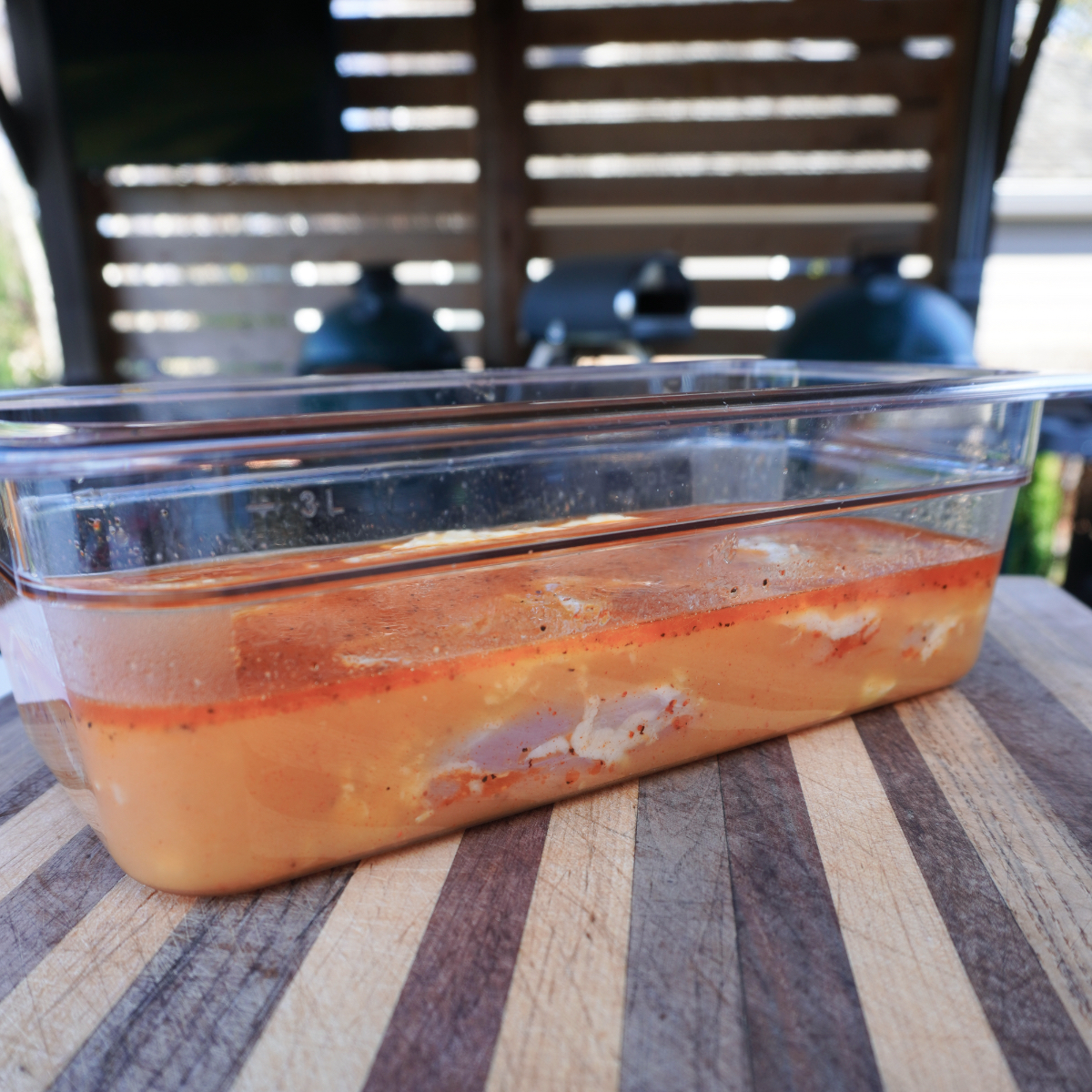 chicken things in the orange marinade in a container. 