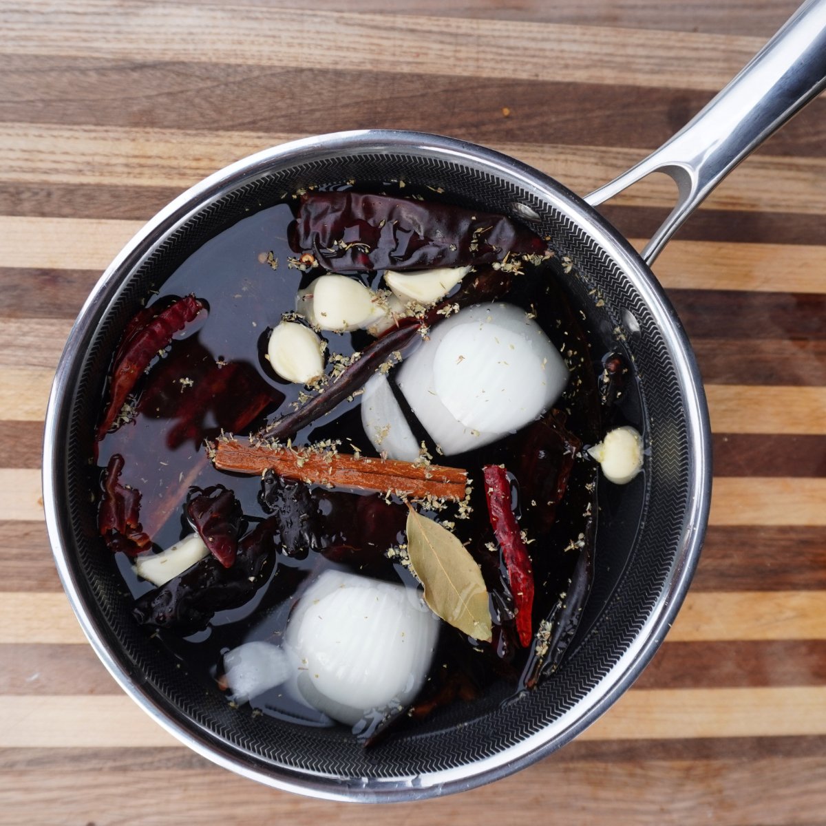 dried chilies and herbs in a saucepan.