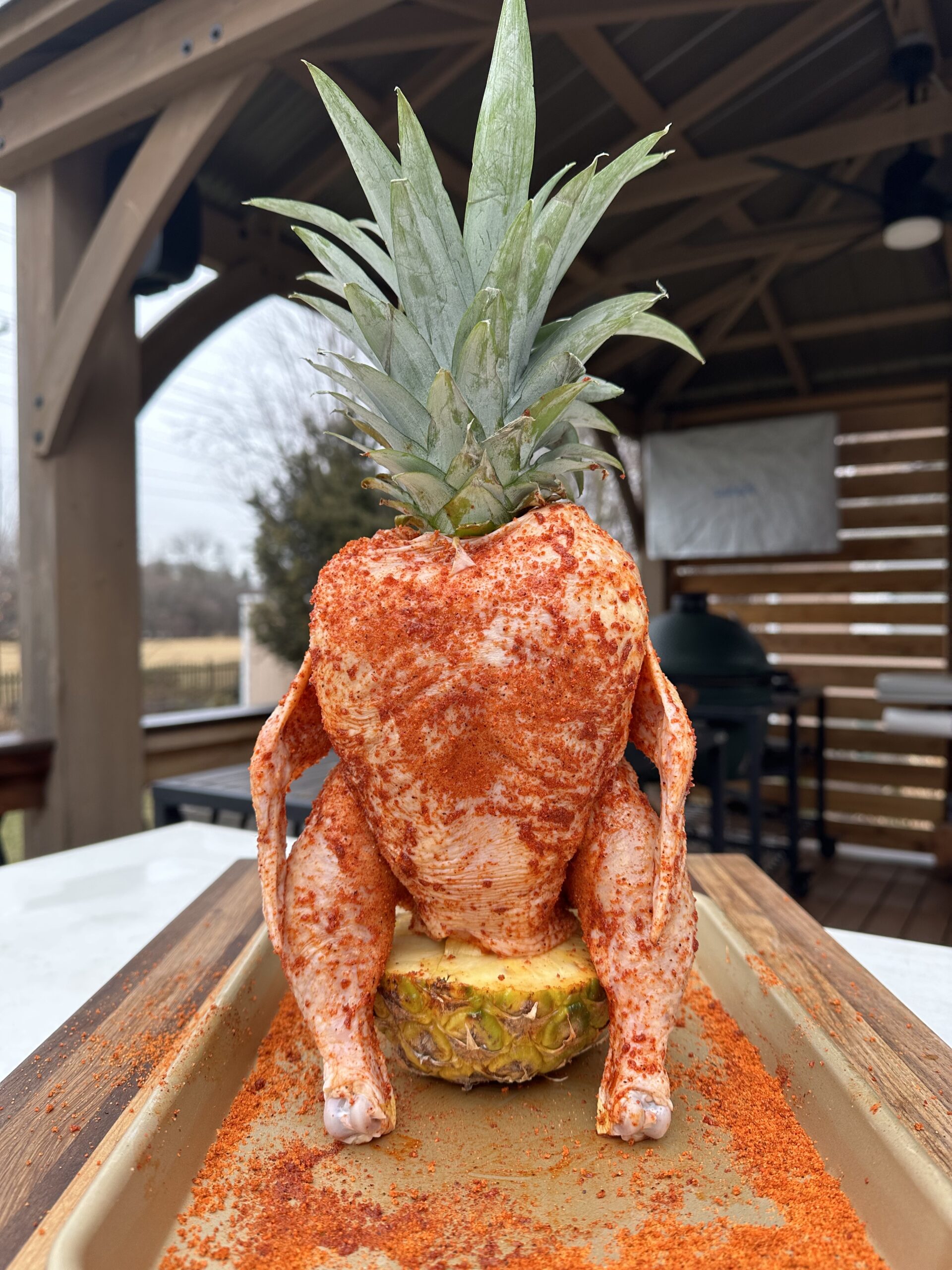 Seasoned chicken sitting on top of a pineapple core. 