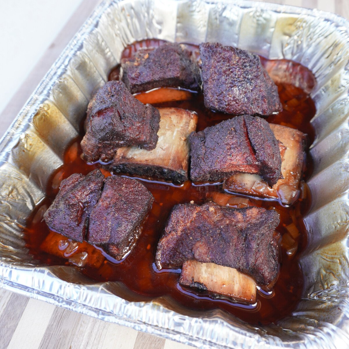cooked short ribs in a foil pan. 