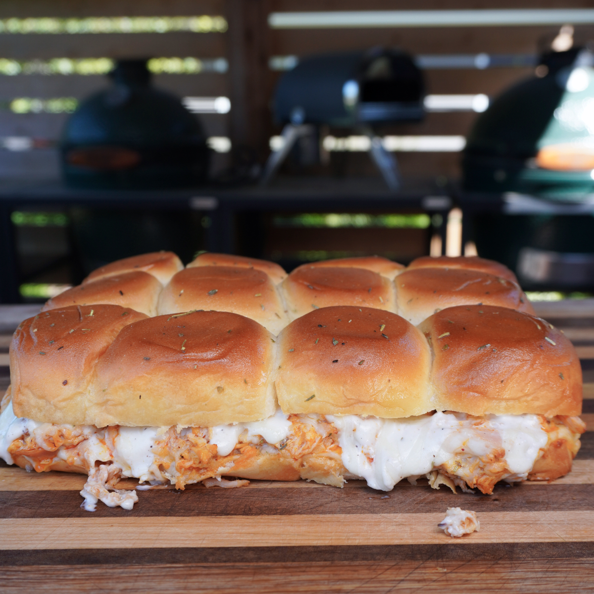 Final buffalo chicken sliders on a wooden cutting board.