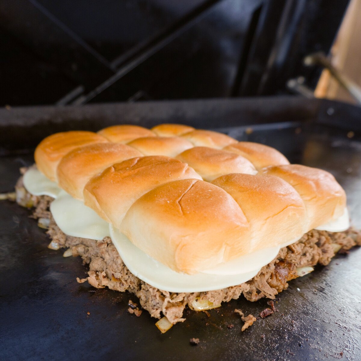 Cheesesteak sliders on the griddle.