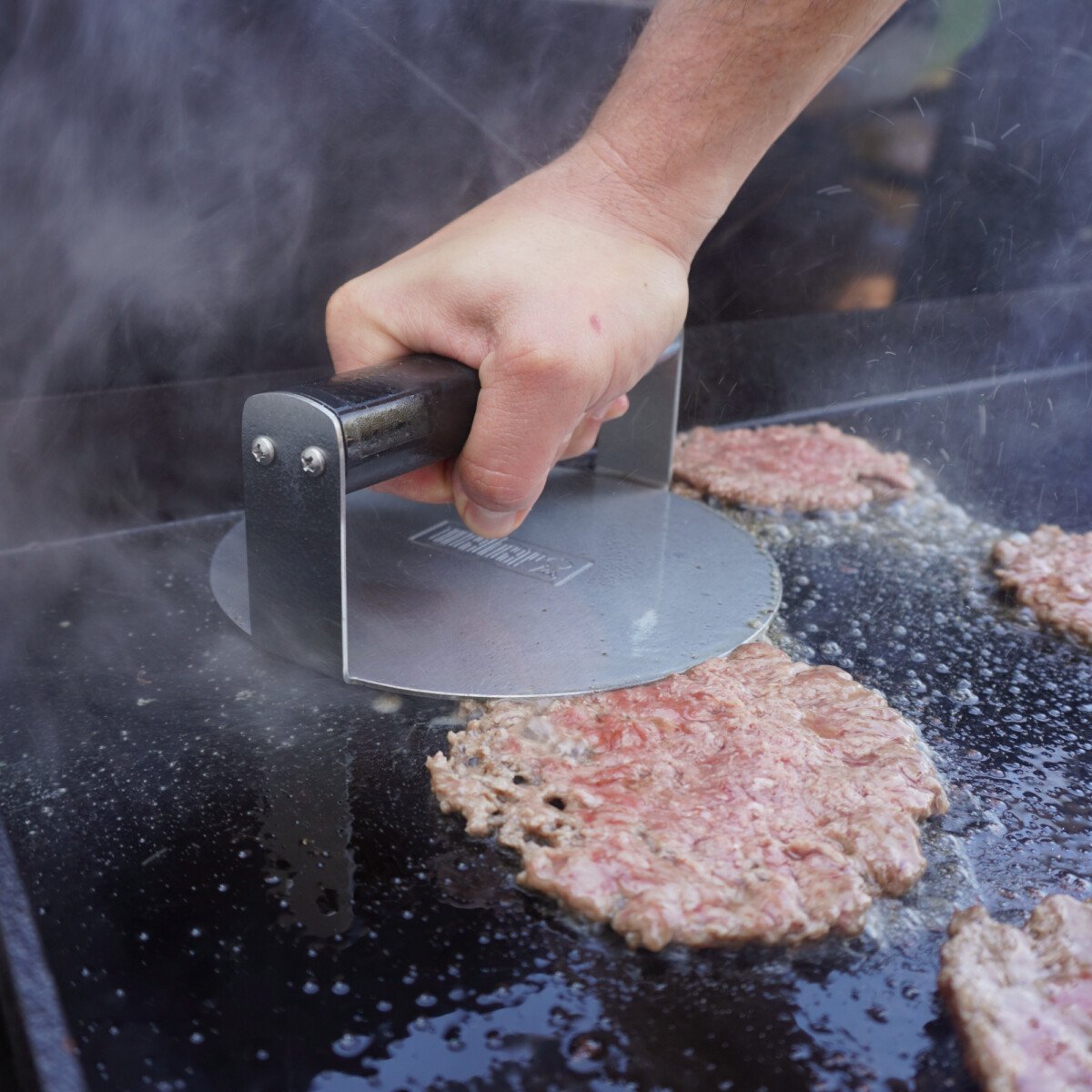 smashing patties on griddle.