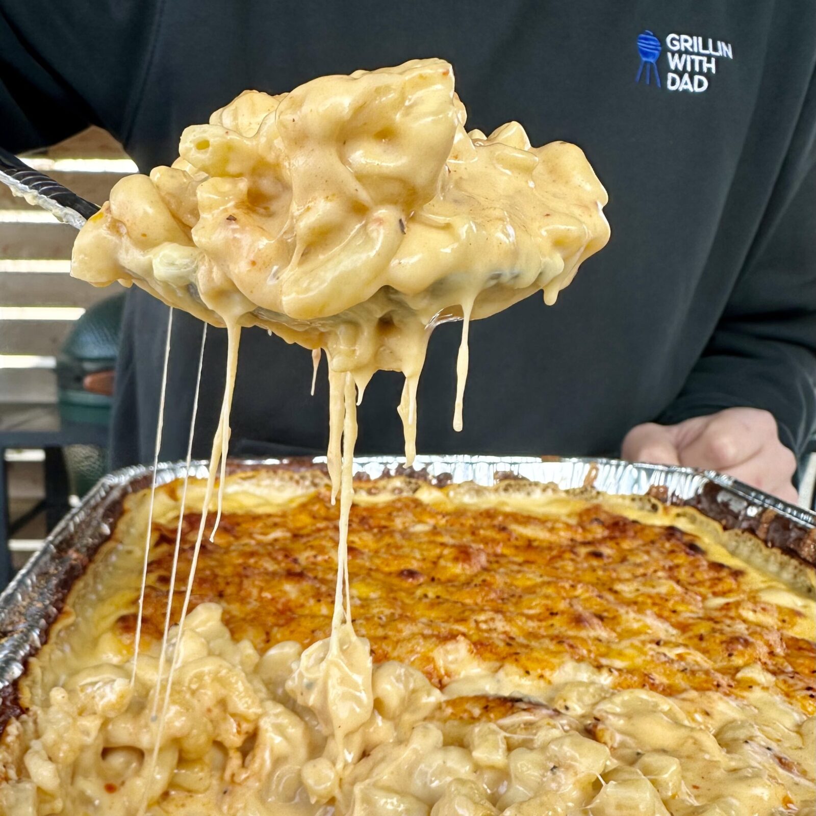 Scopped out creamy and cheese smoked mac and cheese from a foil pan