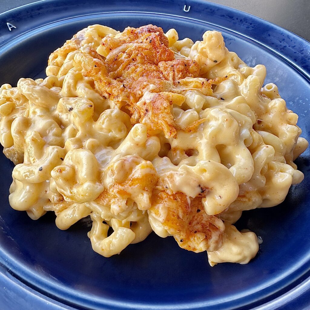 creamy homemade mac and cheese on a blue plate.