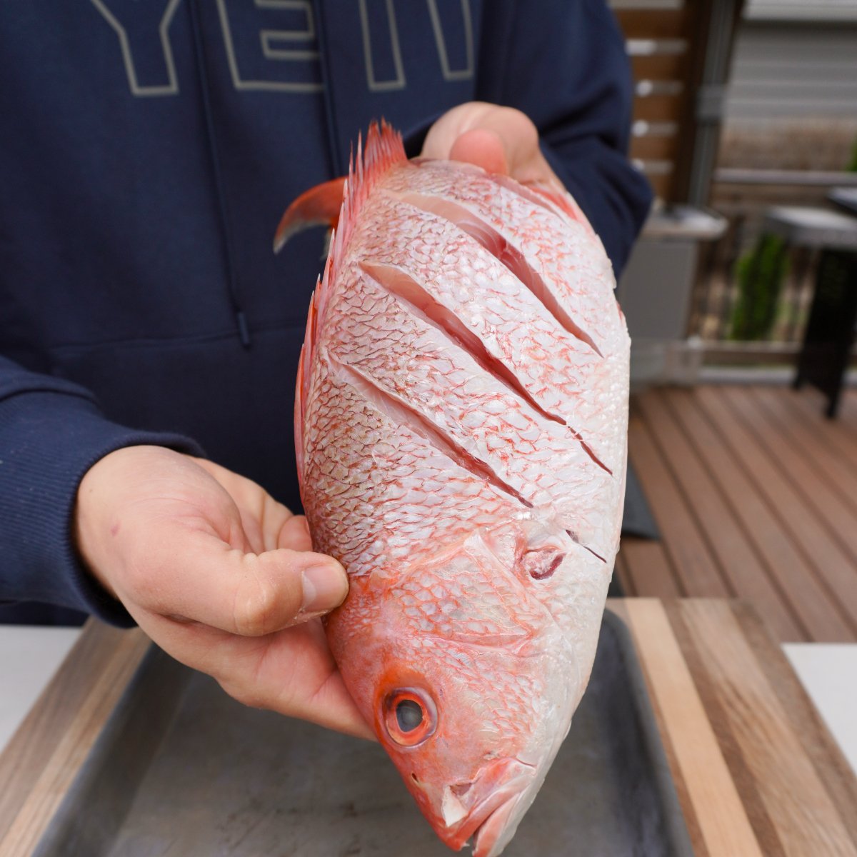 scored raw red snapper.