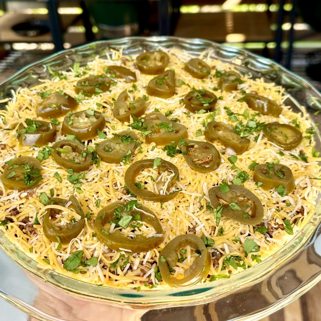eight layer taco dip in a glass container.