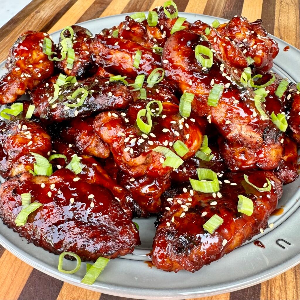 plated wings with gochujang sauce, topped with sesame seeds and scallions. 